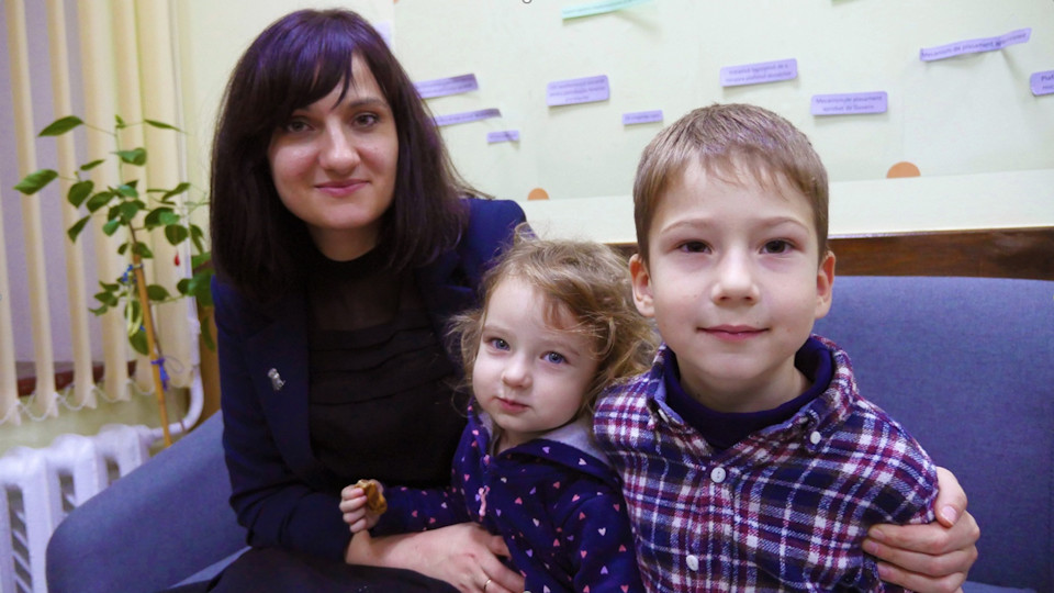 Alina Andronache with two of her children at the office of the Partnership for Development Centre, where she works as a communications specialist. Photo: UN Women/ Tara Milutis